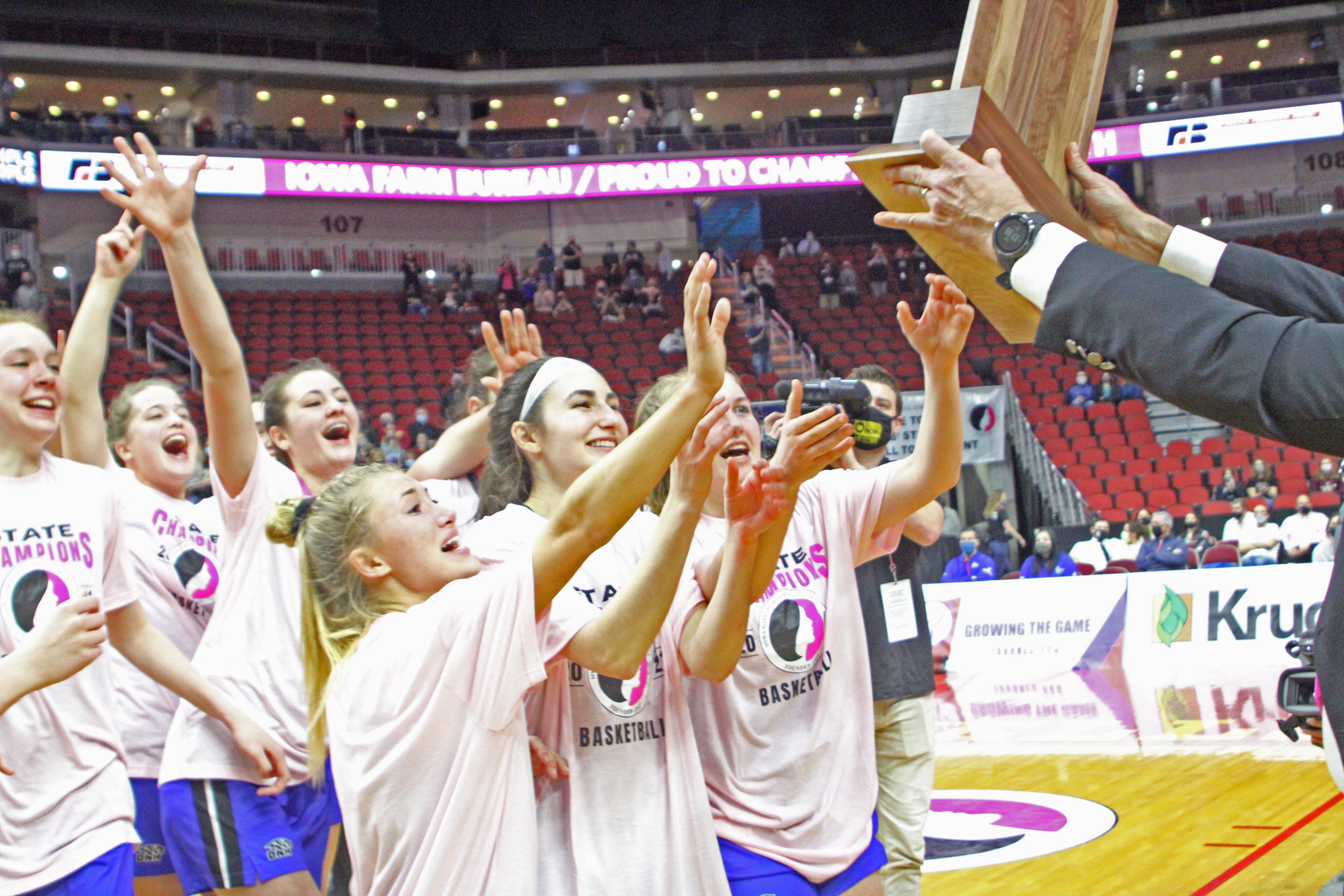 The Dike-New Hartford girls basketball team rushes to collect its Class 2A state championship trophy after an undefeated season in 2021. (Kristi Nixon photo)